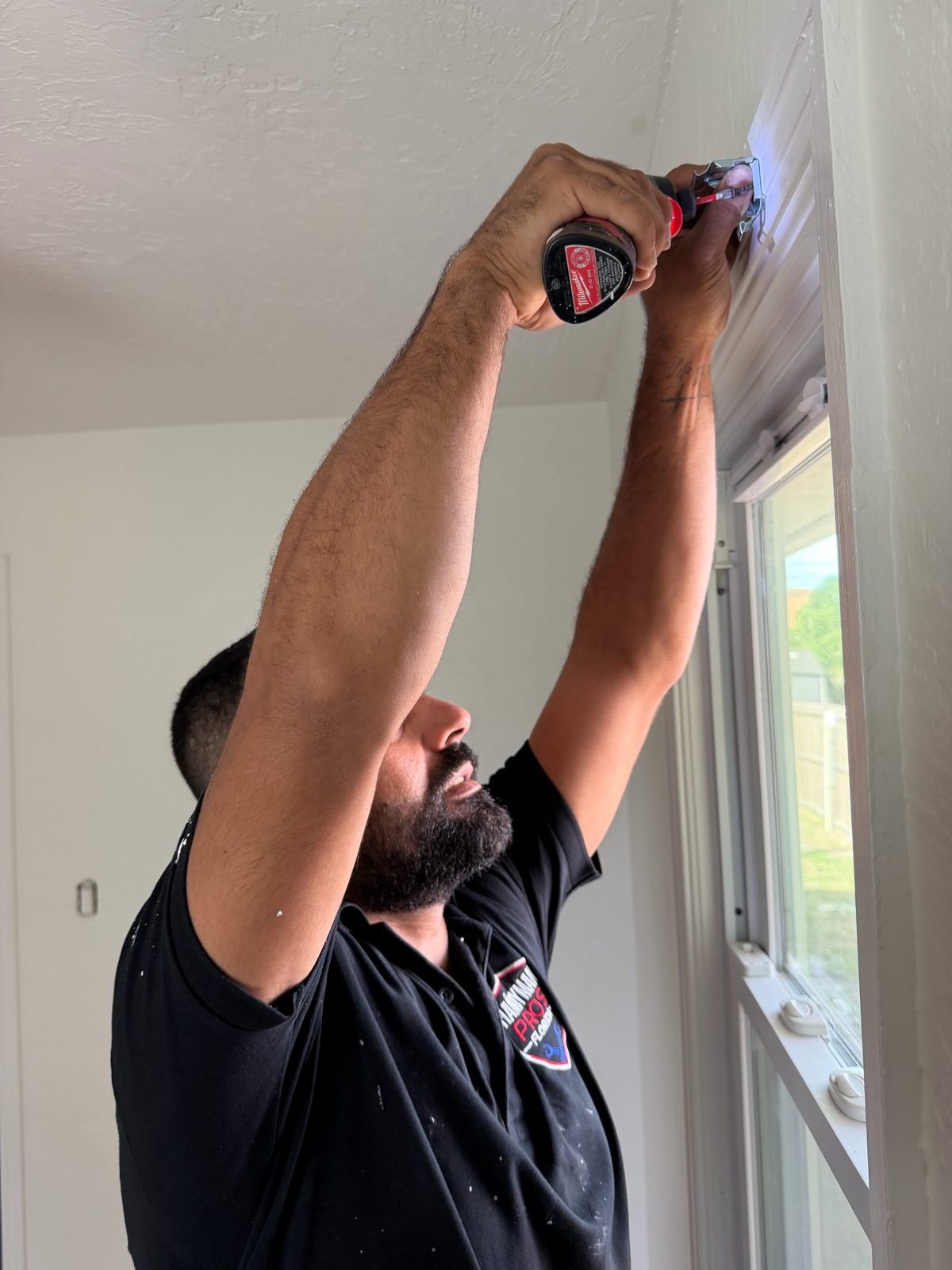 Handyman Pros Florida tech drilling blind hardware into a window frame with a cordless drill