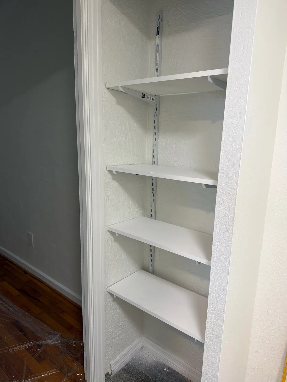 Closet with adjustable white shelves on wall standards installed by Handyman Pros Florida in a Tampa Bay home
