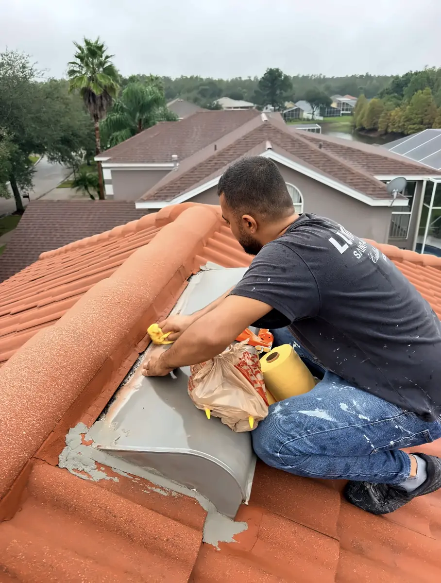Handyman Pros Florida crew member patching mortar around a roof vent on a clay tile roof in the Tampa Bay area