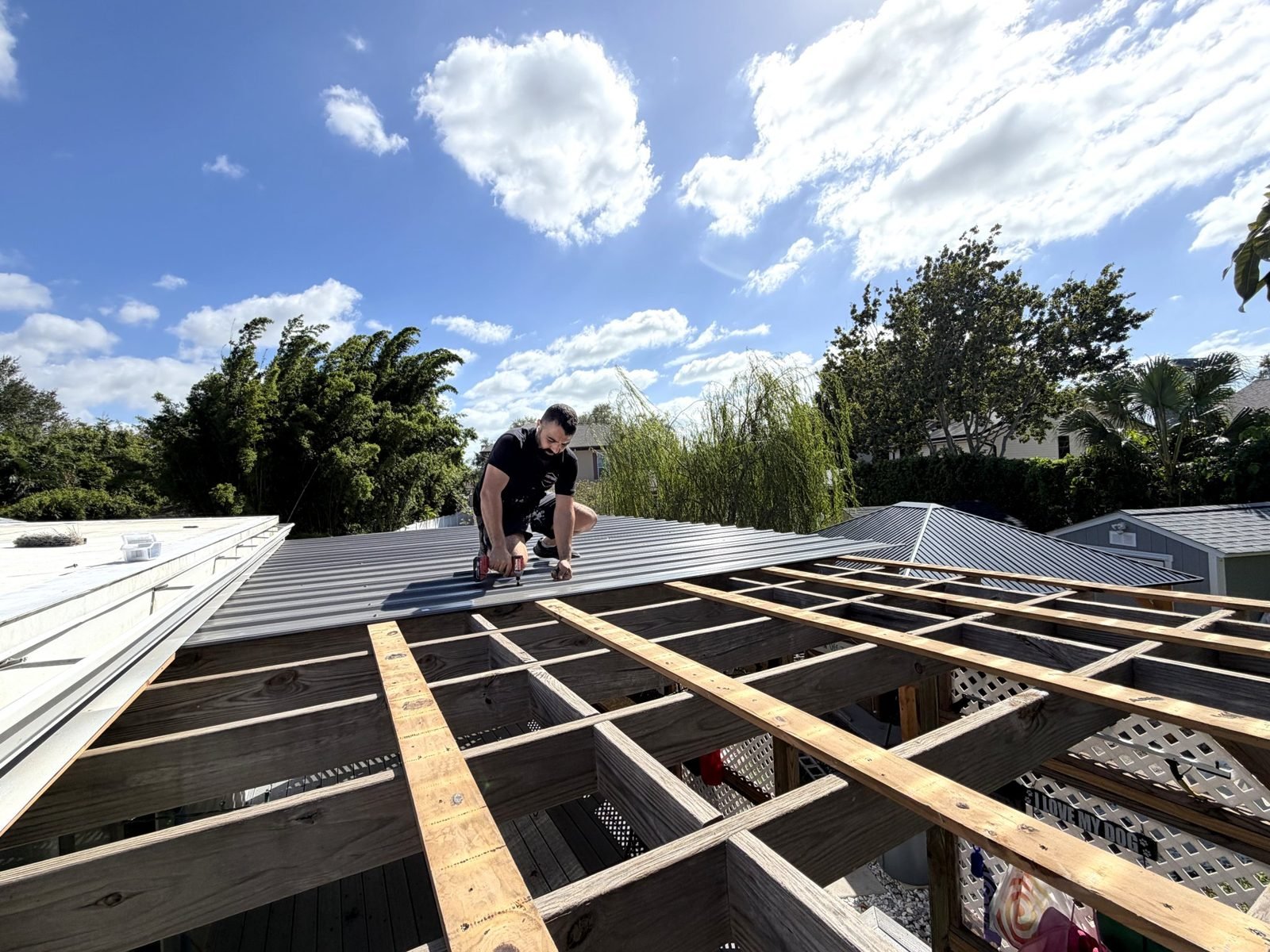 Patio roof built by Handyman Pros FL crew in Tampa, FL — metal roof panels going on over new wood rafters