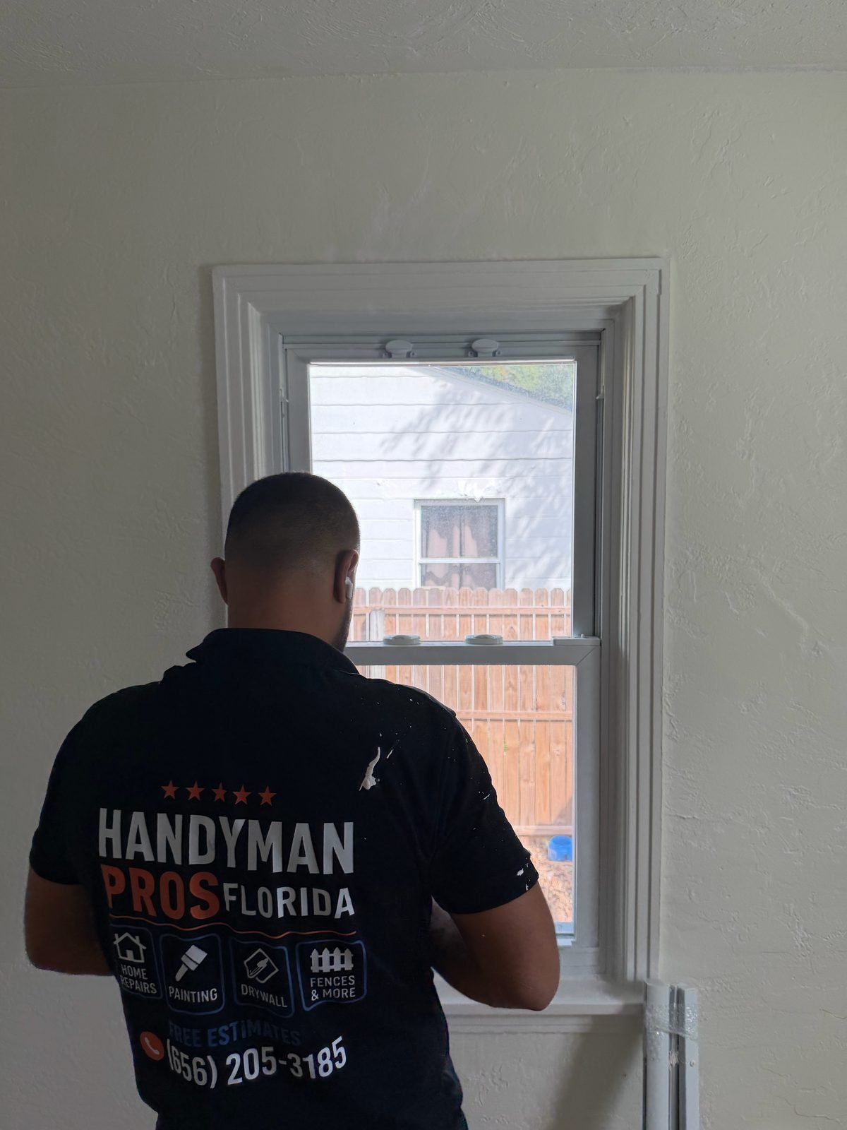 Back of Handyman Pros Florida uniform showing home repairs, painting, drywall, and fences services