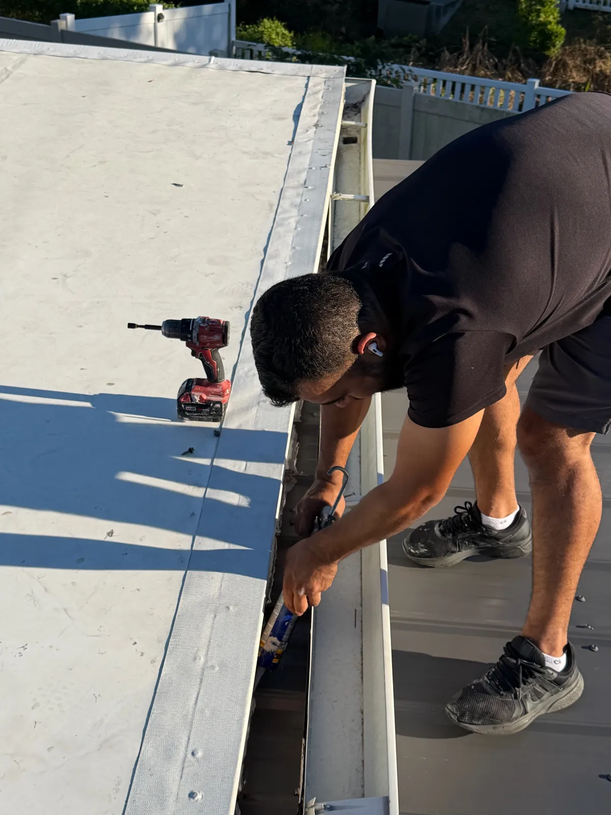 Roof and gutter sealing along a flat roof edge in Tampa Bay